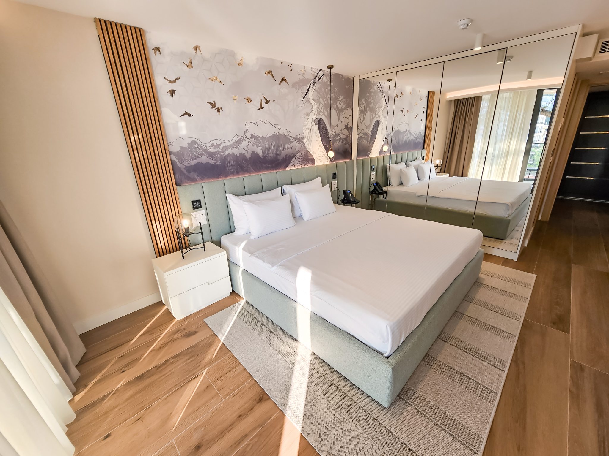 Luksuzna hotelska soba sa King kreveton, ogledalom do poda i planinama na zidu