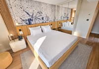 Moderna hotelska soba sa dvokrevetnom posteÑ™om, drvenom ogradom kreveta i umetniÄkim zidnim motivom sa životinjama